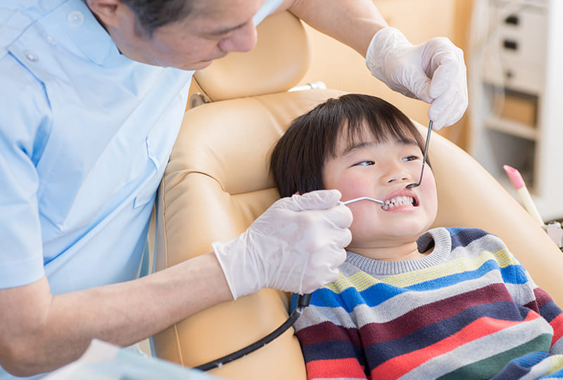 歯科医師から歯の検診をうける男の子